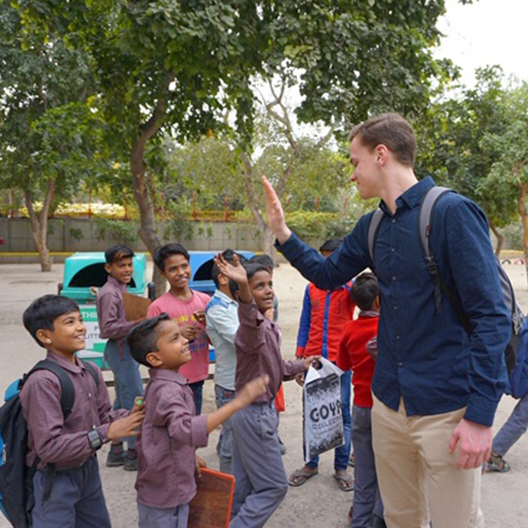 A student high fives a child walking past.